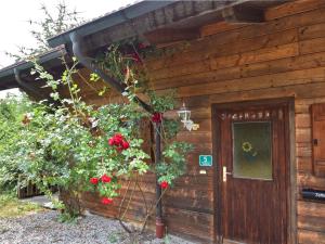 een houten hut met bloemen aan de zijkant bij Vintage Holiday Home in Grafenried with Garden in Drachselsried