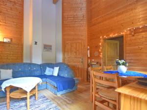 ein Wohnzimmer mit einem blauen Sofa und einem Tisch in der Unterkunft Vintage Holiday Home in Grafenried with Garden in Drachselsried