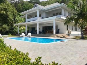 a house with a swimming pool in front of it at Blue Horizon Villas in Pointe Au Sel 