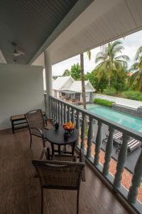 a balcony with a table and chairs and a pool at Souphattra Hotel Luang Prabang in Luang Prabang