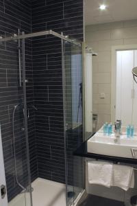 a bathroom with a shower, sink, and toilet at Hotel Lois in A Coruña