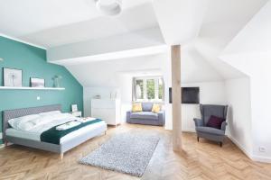 a bedroom with a bed and a chair at Opera Apartments in Poznań