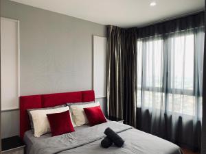 a bedroom with a red headboard and a large window at Stellar Homes at iCity - with WiFi and 2 Private Carparks in Shah Alam