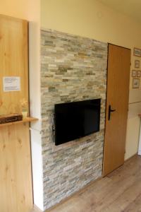 a stone fireplace with a television on a wall at Apartmán Turista in Pavčina Lehota