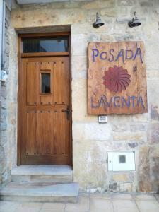 Posada laventa في Selaya: باب خشبي على جانب مبنى عليه لافته
