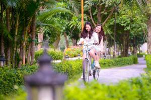 two women riding a bike in a park at FLC Luxury Resort Vinh Phuc in Hoằng Xá