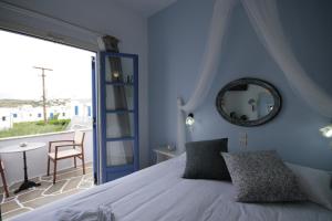 a bedroom with a bed with a mirror and a balcony at Pension Sofia in Parikia