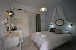 a bedroom with a white bed and a sink at Pension Sofia in Parikia