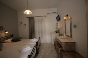 a room with a bed and a sink and a mirror at Pension Sofia in Parikia