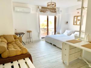 a bedroom with a bed and a couch and a desk at Vapori Otel in Bozcaada