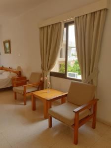 una stanza con due sedie e un letto e una finestra di Arilena Holiday Apartments a Paphos Altre 59 foto