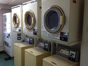 three washing machines are lined up in a room at Ace Inn Kariya in Kariya