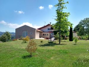 ein Haus auf einem Feld mit einem Rasenplatz in der Unterkunft En la colina 2 Montañealde in Gamiz-Fika