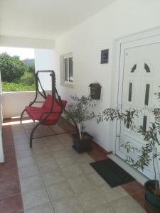 a red chair sitting on a balcony with plants at Apartman Leo in Brela +3 photos