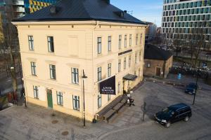 a large white building with a black roof in a city at Livin Station Hotel in Örebro