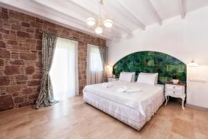 a bedroom with a large bed and a brick wall at Cunda Fora Hotel in Ayvalık
