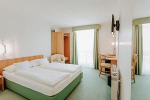 バーデン・バーデンにあるHuber's Hotelのベッドとデスクが備わるホテルルームと +37枚の写真