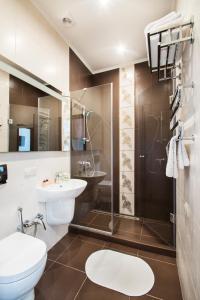 a bathroom with a toilet and a sink and a shower at Flatlux Apartments in Kyiv