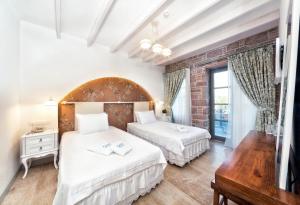 فندق كوندا فورا  في أيفاليك: سريرين في غرفة مع جدار من الطوب