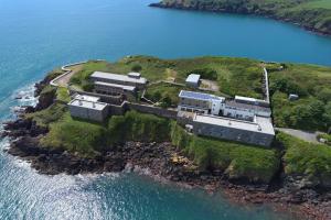 an aerial view of a house on an island in the water at FSC Dale Fort Hostel in Haverfordwest