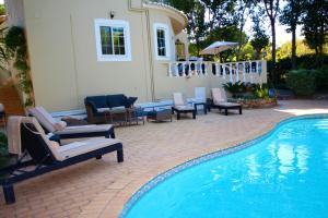 a swimming pool with lounge chairs and a house at Casa Roma in Almancil