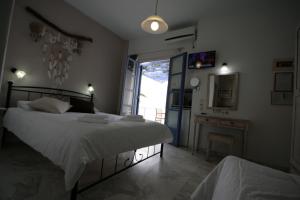 a bedroom with two beds and a television in it at Pension Sofia in Parikia