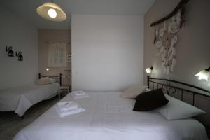 a bedroom with a large white bed with two pillows at Pension Sofia in Parikia
