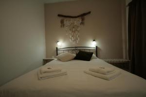 a bedroom with a white bed with towels on it at Pension Sofia in Parikia