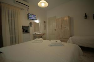 a bedroom with a white bed with two towels on it at Pension Sofia in Parikia