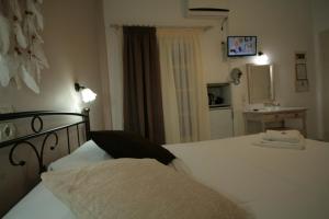 a bedroom with a white bed and a mirror at Pension Sofia in Parikia