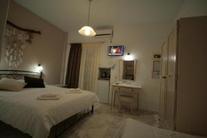 a bedroom with a bed and a desk and a television at Pension Sofia in Parikia