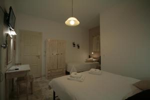 a white room with a bed and a sink and a bedroom at Pension Sofia in Parikia