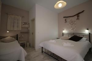 a bedroom with two beds with white sheets at Pension Sofia in Parikia