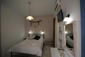 a bedroom with a white bed and a mirror at Pension Sofia in Parikia