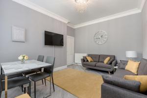 een woonkamer met een bank en een tafel bij No 46 - by StayDunfermline in Dunfermline