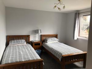 a bedroom with two beds and a window at Fairwinds in Inverness