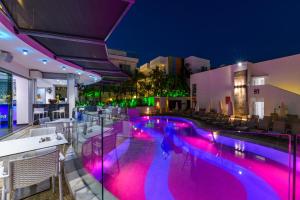 Tasia Maris Oasis في أيا نابا: حمام سباحة في الليل مع إضاءة أرجوانية