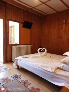 a bedroom with a bed with two white swans on it at Casa Rodica str. Clabucetului 28 in Buşteni