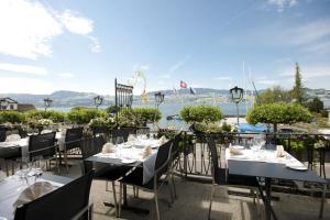Gasthof zur Sonne في ستافا: مطعم على طاولات وكراسي على شرفة