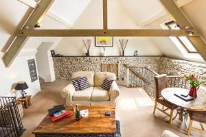a living room with a couch and a table at Red Doors Farm Cottages in Honiton