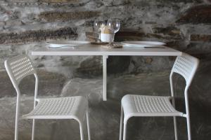 a white table with two chairs and a table and two glasses at Gaia Vacation Home in Agia Mavra