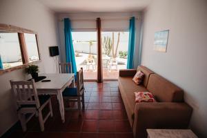 a living room with a couch and a table at Apartamentos Punta Elena Beach in Corralejo