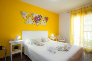 1 dormitorio con cama blanca y pared amarilla en Singularstays Ruzafa Terrace, en Valencia