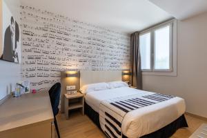 um quarto com uma cama e uma parede de escrita em Casual del Jazz San Sebastián em San Sebastián