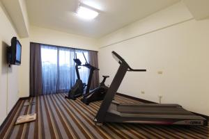 a gym with two tread machines in a room at Metro Hotel in Douliu