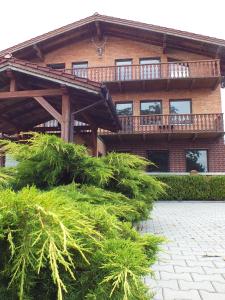 a house with a deck on top of some bushes at Akacjowy in Ostrowite