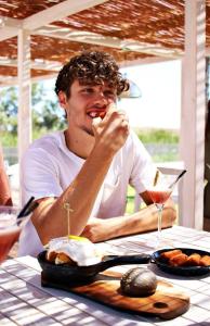 a man sitting at a table eating food at Hotel Clipper - EL DELFÍN VERDE RESORTS - Platja de Pals in Torroella de Montgrí