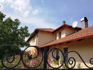 a fence in front of a house with flowers at Kincsesbánya in Kincsesbanya