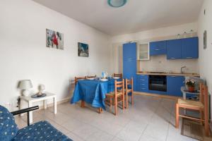 a kitchen with blue cabinets and a table with chairs at L'Agrumeto a Marittima by BarbarHouse in Marittima