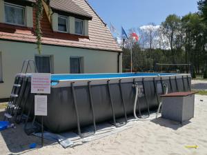 a swimming pool in front of a house at Ośrodek Wypoczynkowy Merkury in Mrzeżyno